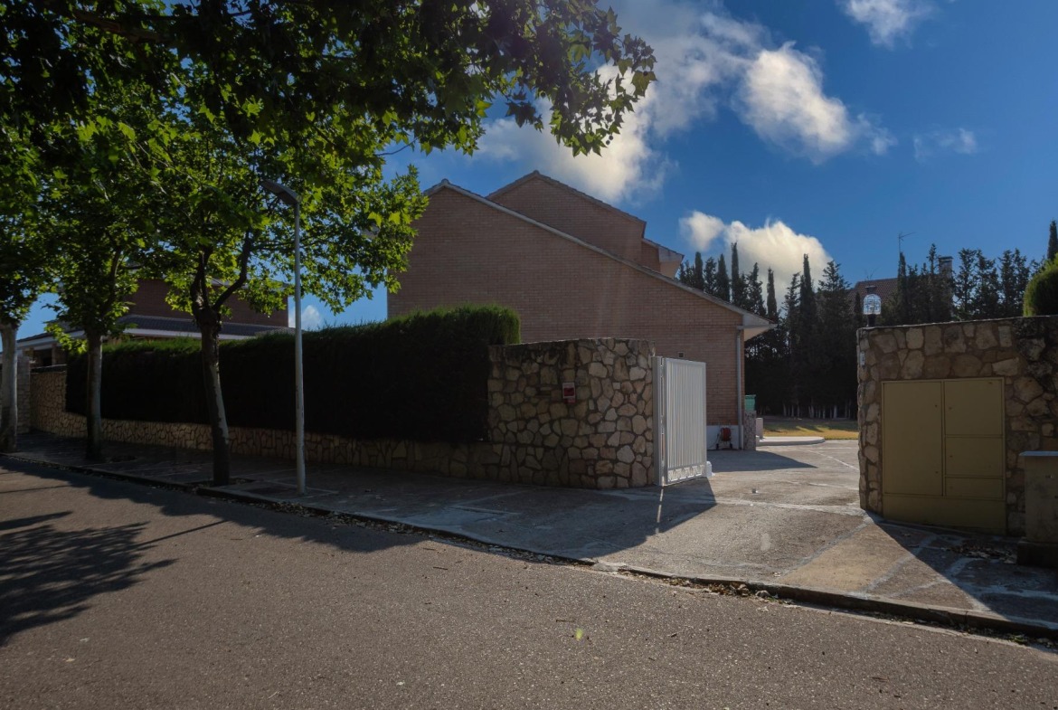 Calle residencial de Zuera, con tapias de ladrillo y arbolado.