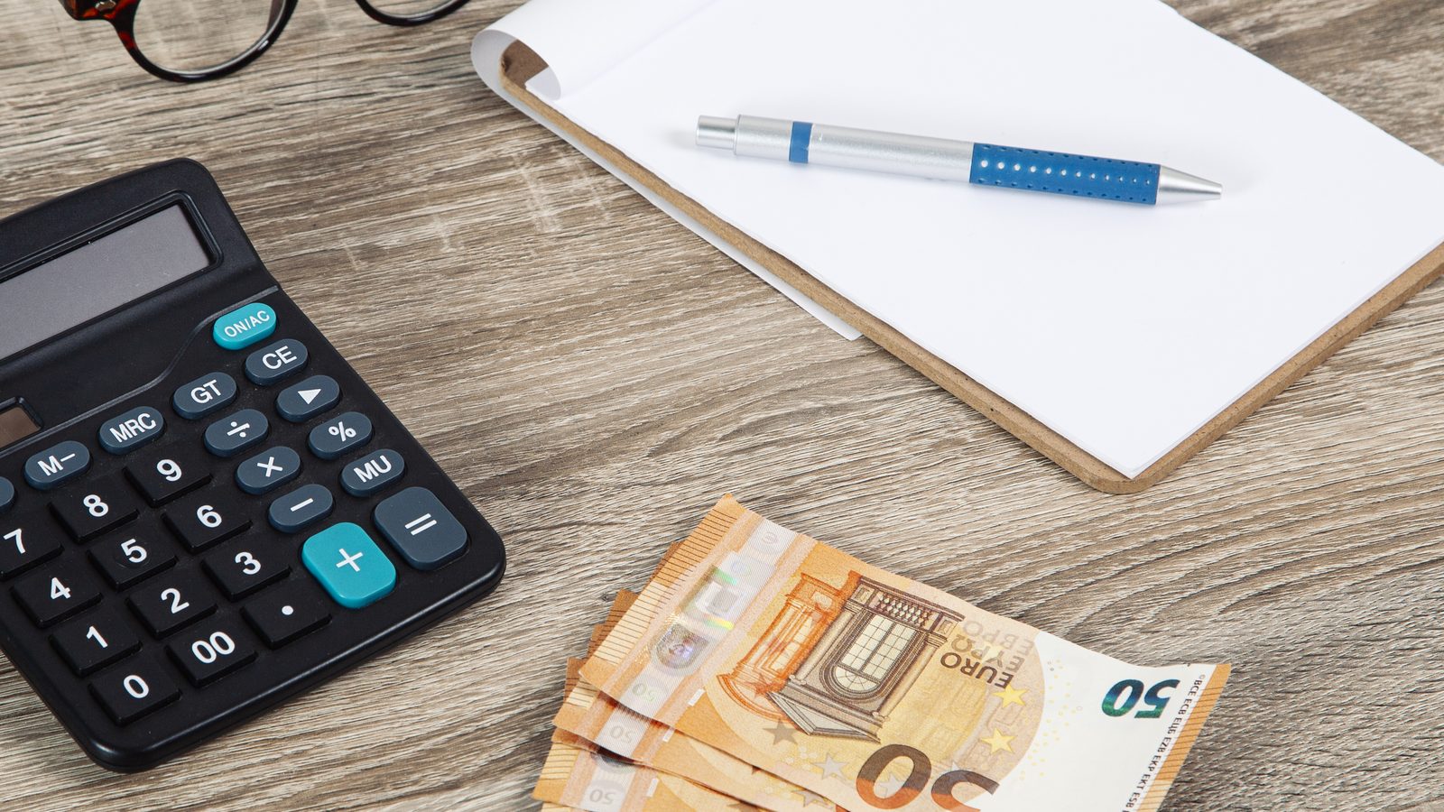 Calculadora y billetes de euro para calcular los impuestos al vender un piso en Zaragoza