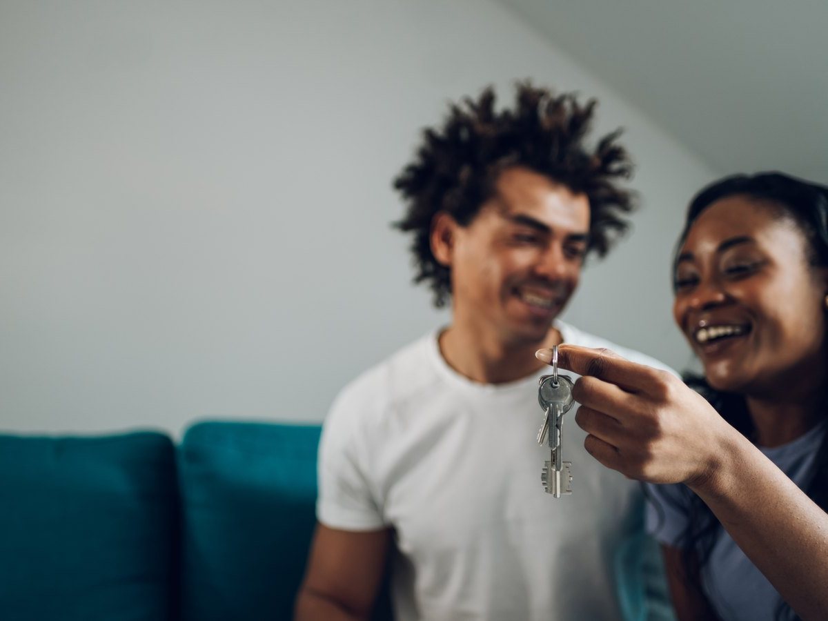 Impuestos al comprar una vivienda en Aragón: ITP, IVA y AJD 3 Pareja joven con las llaves de su primera vivienda en Zaragoza