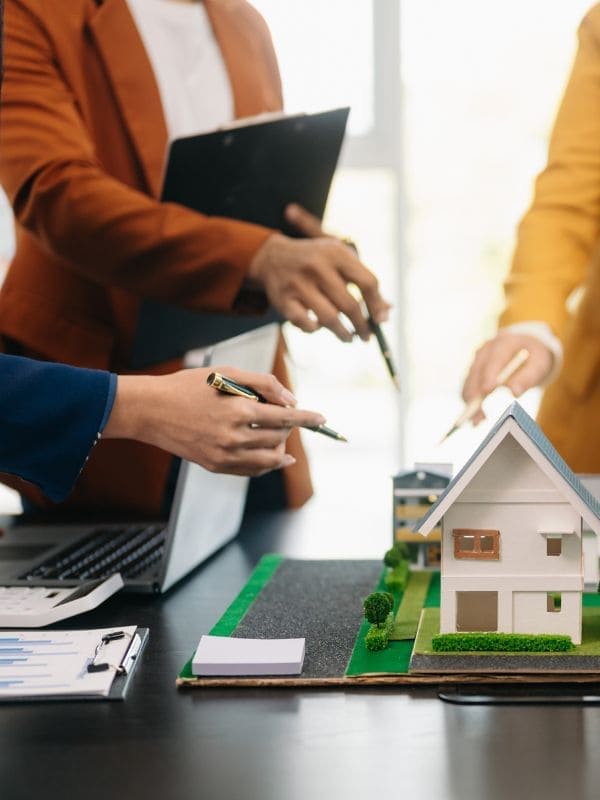 Comprar casa en Brea de Aragón 7 Manos señalando la maqueta de una casa, casas en venta en Brea de Aragón