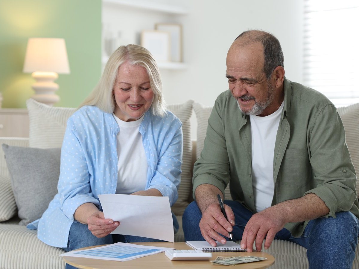 Valor catastral y valor de mercado: en qué se diferencian 3 Pareja revisando en casa los recibos donde aparece el valor catastral de su vivienda