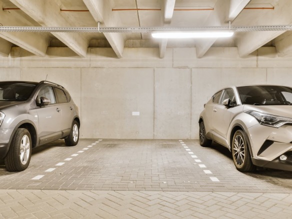 Plaza de garaje libre y marcada entre dos coches aparcados