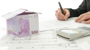 Casita hecha con billetes de 500 euros, calculadora y firma de un documento: cuánto cobra una inmobiliaria por vender un piso en Huesca