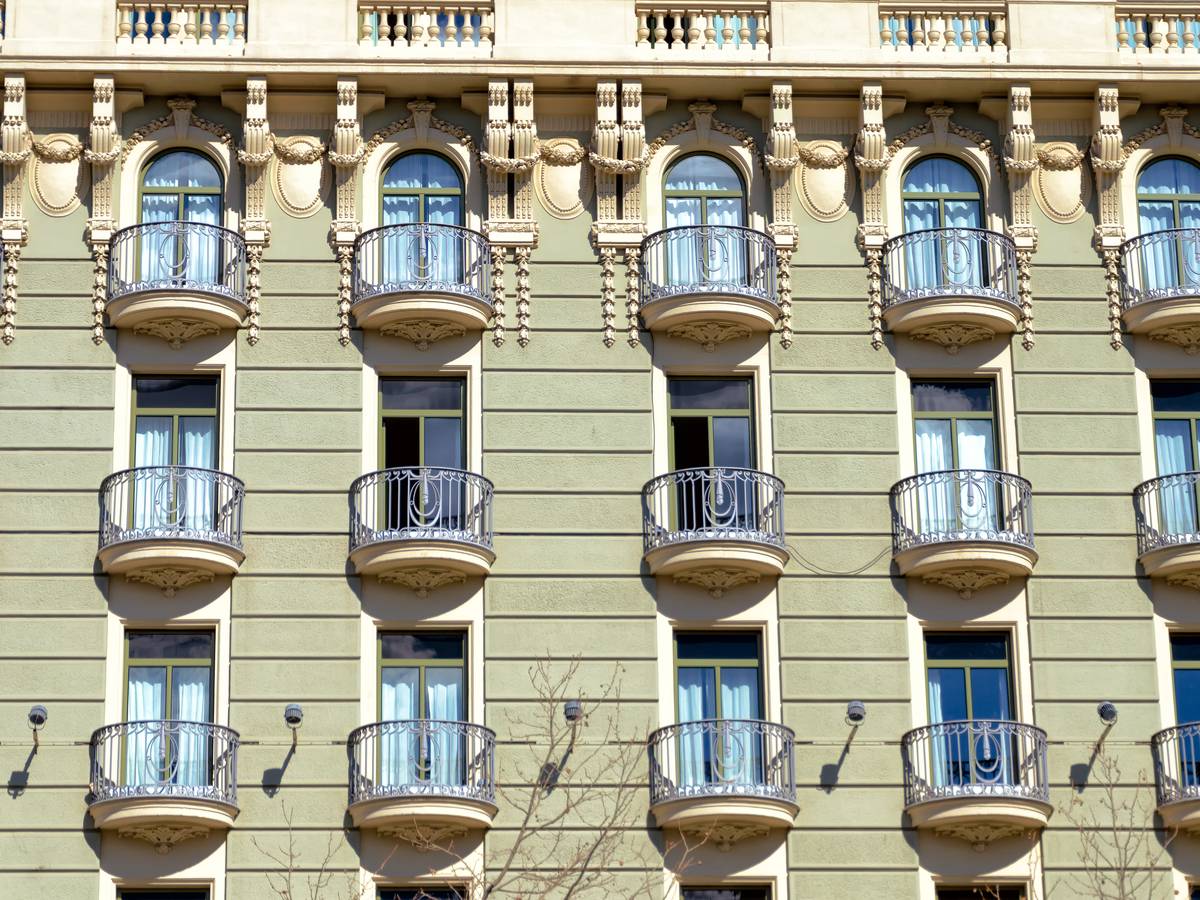 ¿Cuánto cobra una inmobiliaria por vender un piso en Tarragona? Comisión, ley catalana y gastos del vendedor 1 Fachada de un edificio de pisos con balcones de forja: gastos de vender un piso en Tarragona