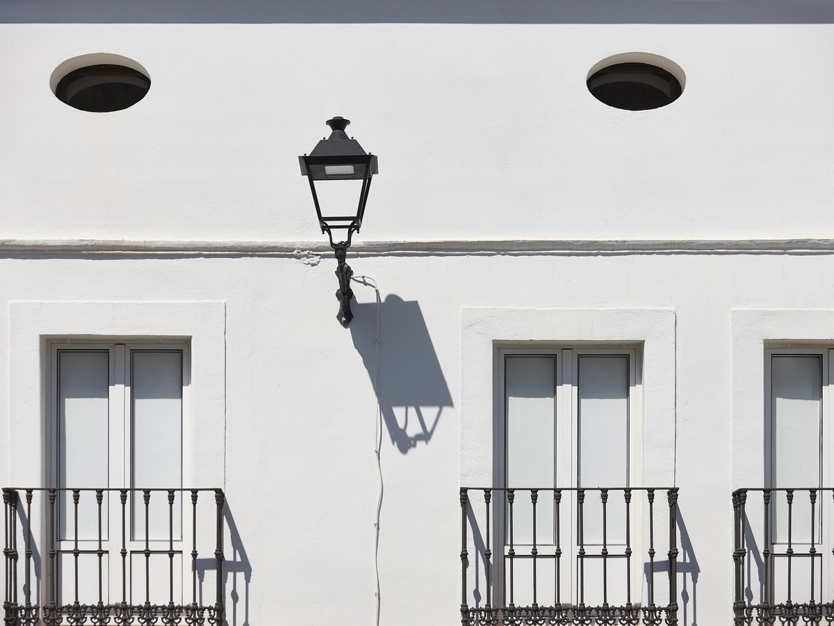 ¿Cuánto cuesta comprar una vivienda en Tarragona? Impuestos y gastos en 2026 1 Fachada blanca con balcones de hierro y un farol: impuestos de comprar un piso en Tarragona